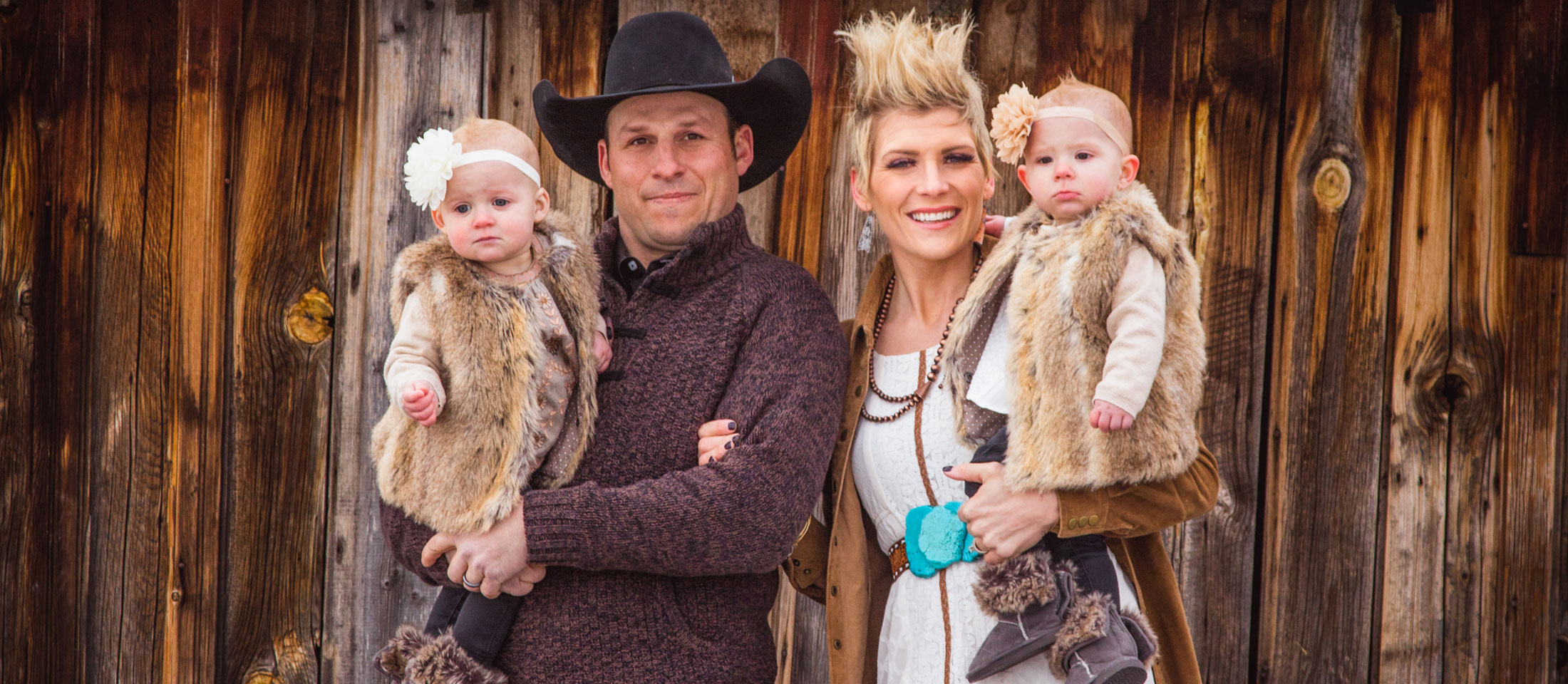 A family photo in front of an old barn.